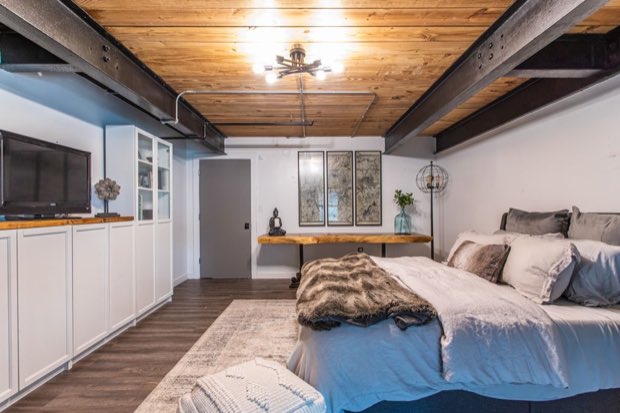 Main-floor bedroom looking toward the built-in cabinetry and wall-mounted television