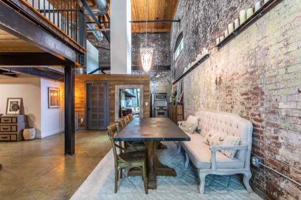 Dining area beneath the mezzanine, with exposed ductwork and brick