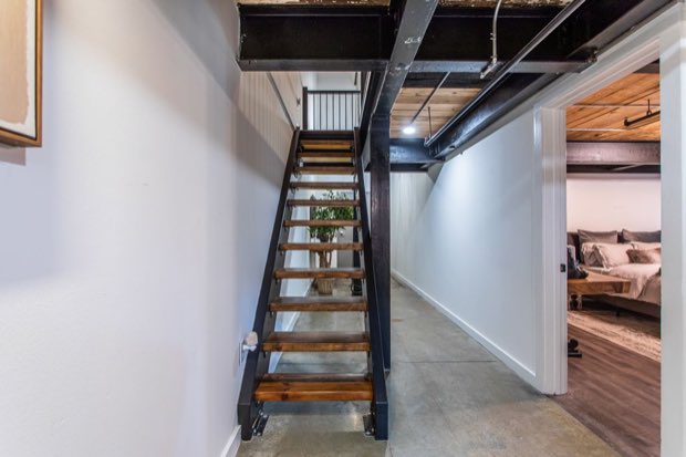 Open-tread stair to the mezzanine, with the main-floor bedroom beyond