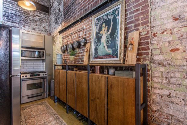 Kitchen wall with hanging copper pans and a reclaimed wood sideboard