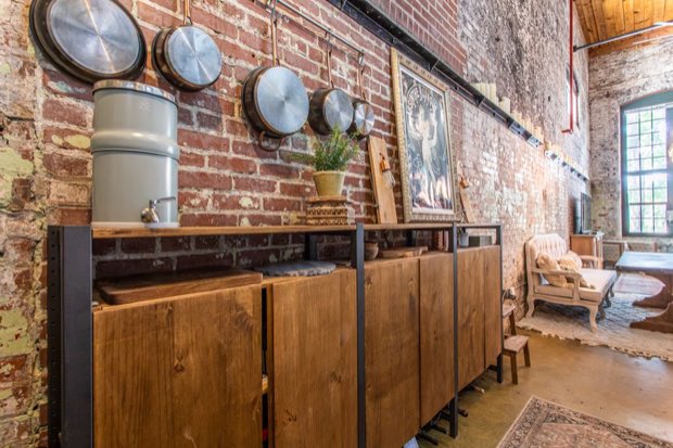 Reclaimed wood sideboard against exposed brick, looking through to the living area