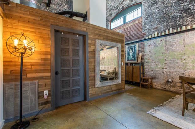 Reclaimed wood partition wall with a carved door and leaning mirror
