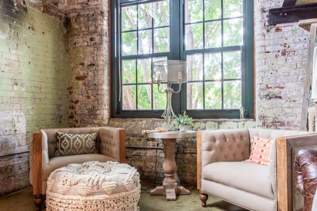Seating nook beneath the factory window, with brick walls and a table lamp