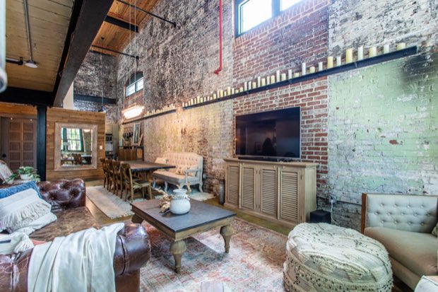 Living area with brick walls, candle rail and the dining table beyond