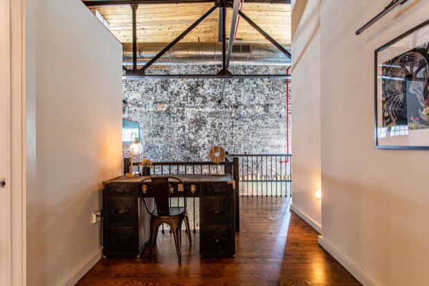 Mezzanine study looking out across the double-height brick wall