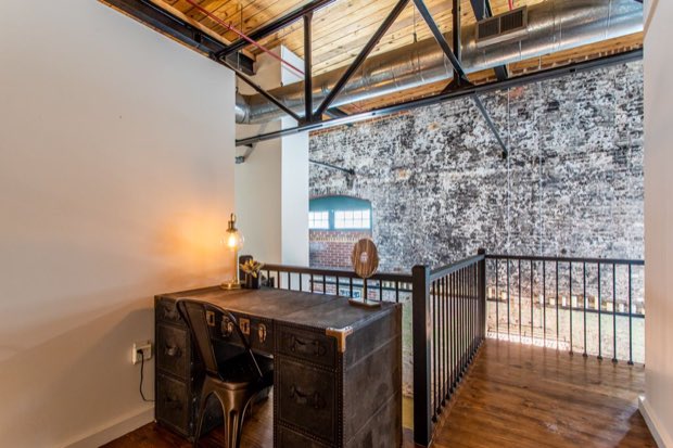 Mezzanine study with a campaign desk beside the railing