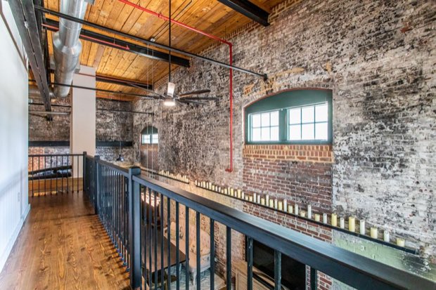 Mezzanine walkway with wide plank floors, railing and exposed ductwork