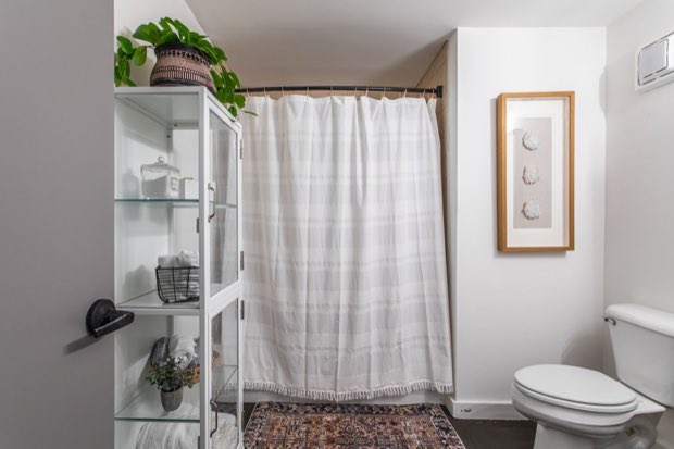 Main-floor bathroom with a glass display cabinet beside the shower