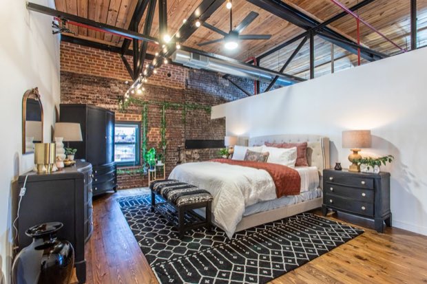 Loft bedroom looking toward the brick wall and factory window