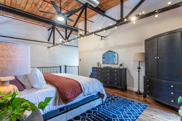 Loft bedroom with the mezzanine railing and steel trusses overhead