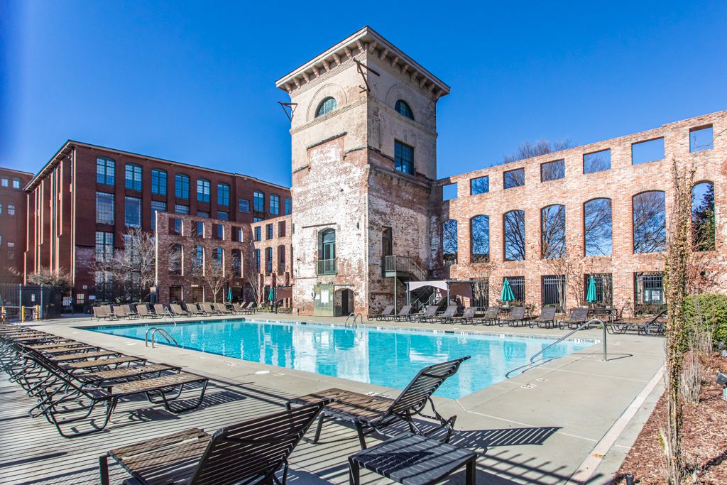 Community pool below the mill's water tower, with the loft buildings beyond
