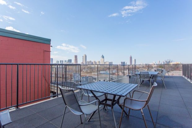 Rooftop deck seating with the downtown skyline in the distance
