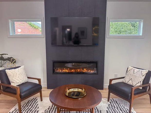 Charcoal tile fireplace wall flanked by a pair of leather lounge chairs