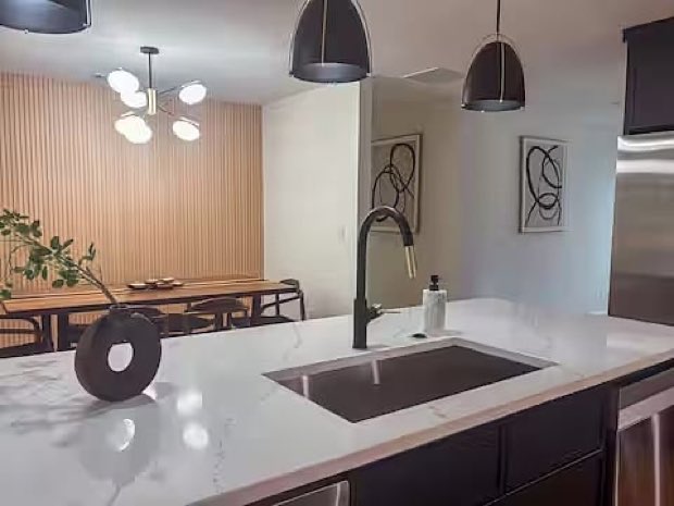 Island sink and matte black faucet, with the dining area beyond