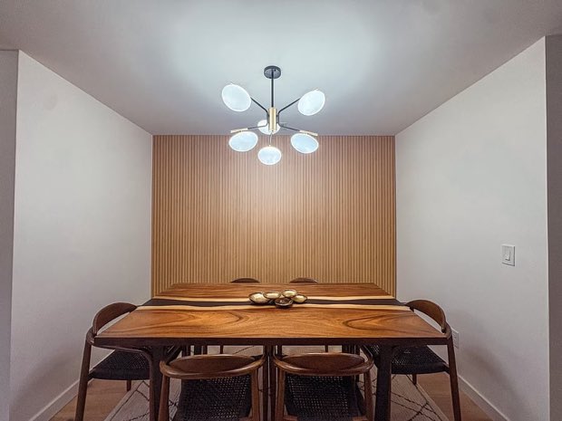 Walnut dining table for six against the white oak slat wall