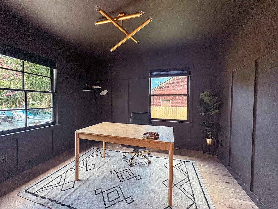 Dedicated home office with charcoal board-and-batten walls and a light wood desk