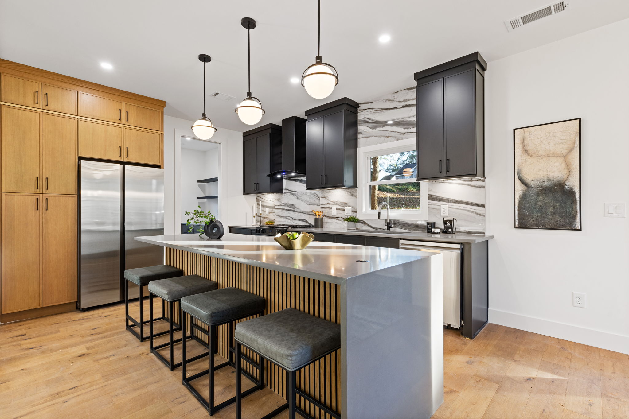 Kitchen with a large island, bar stools and custom cabinetry