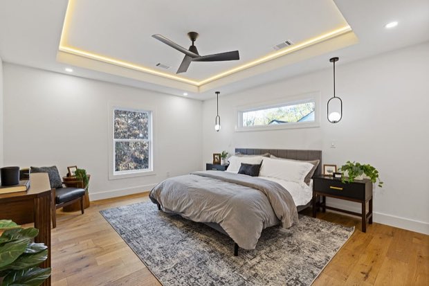 Primary bedroom with a tray ceiling and accent lighting