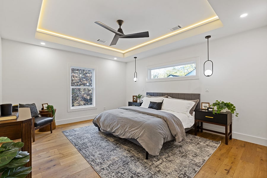 Primary bedroom with a tray ceiling and accent lighting