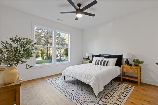 Main-floor queen bedroom with a ceiling fan