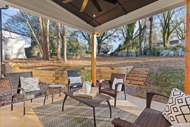 Covered patio seating shaded by mature trees