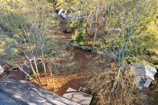 Aerial view of the backyard and the wooded lot behind the home