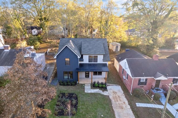 Aerial view of the home from the front, with the neighborhood beyond